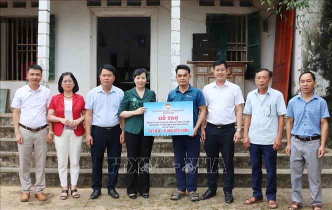 Chủ tịch Ủy ban MTTQ tỉnh Bắc Ninh Nguyễn Thị Hà trao kinh hỗ trợ cho hộ anh Lê Văn Tuấn, thôn La Thành. Ảnh: Thanh Thương - TTXVN