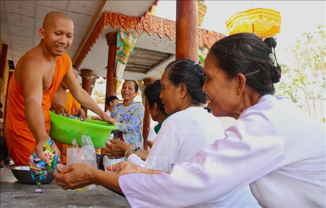 Đồng bào phật tử đón nhận những viên kẹo từ nhà sư với ý nghĩa đón nhận những điều tốt đẹp trong năm mới. Ảnh: Nguyễn Hằng - TTXVN
