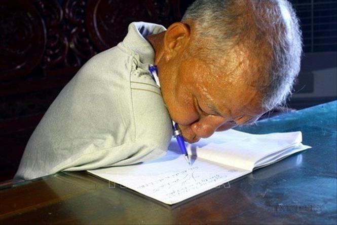 Người đàn ông thiếu hai tay Hoa Xuân Tứ (sinh năm 1950, trú tại xóm 2, xã Châu Nhân, huyện Hưng Nguyên, tỉnh Nghệ An) là tấm gương tiêu biểu về tinh thần vượt qua mọi khó khăn, rèn ý chí, nghị lực để vươn lên trong cuộc sống. Ảnh: Tá Chuyên -TTXVN