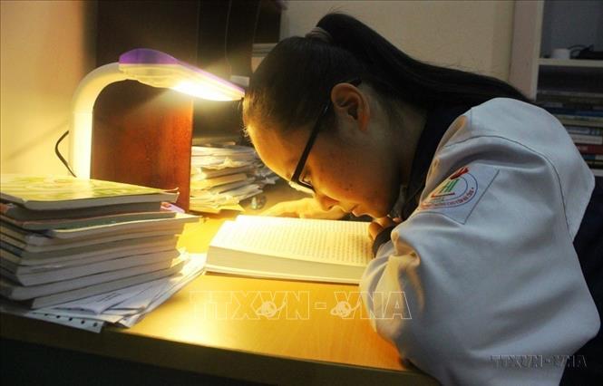 Bị khiếm thị bẩm sinh, nhưng em Dương Thị Mai Phương (học sinh lớp 11 Văn, trường THPT Chuyên Hà Tĩnh) đã nỗ lực vượt khó, vươn lên trong cuộc sống và hòa nhập cùng bạn bè. Đáng khâm phục hơn, em đã xuất sắc giành giải Ba trong kỳ thi học sinh giỏi Quốc gia năm 2020 môn Lịch sử. Ảnh: Hoàng Ngà - TTXVN