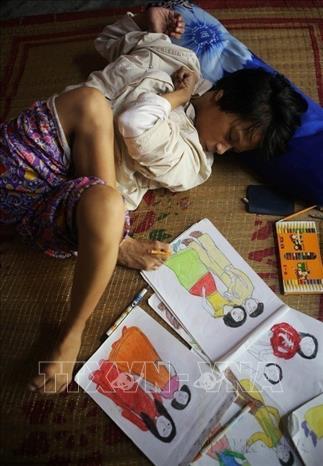 Mặc dù bị tật nguyền, chân tay co quắp, nhưng với ý chí và nghị lực, chị Huỳnh Thị Thảnh, ở thôn Hải Tân, xã Hương Bình, thị xã Hương Trà (Thừa Thiên-Huế) đã dùng đôi chân vẽ nên những bức tranh đẹp. Ảnh: Hồ Cầu - TTXVN