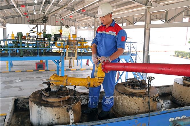 Công nhân Công ty Cổ phần Xăng dầu Dầu khí Vũng Áng thực hiện quy trình nạp hàng từ kho chứa lên hầm xe thông qua hệ thống vòi bơm chuyên dụng. Ảnh: Hữu Quyết – TTXVN 