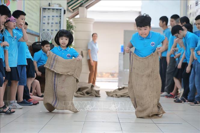 Học sinh tiểu học Bình Minh hào hứng tranh tài nội dung nhảy bao bố trong ngày hội thể thao. Ảnh: Lê Đông - TTXVN