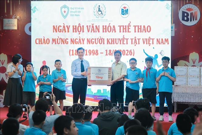 Ông Đặng Hữu Quỳ, Chánh Văn phòng Hội cứu trợ Trẻ em khuyết tật thành phố Hà Nội trao tặng phần quà cho nhà trường. Ảnh: Lê Đông - TTXVN