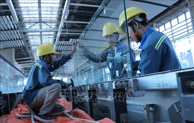 Người lao động lắp đặt hệ thống thang bộ hành tại nhà ga hành khách sân bay Long Thành. Ảnh: Công Phong - TTXVN