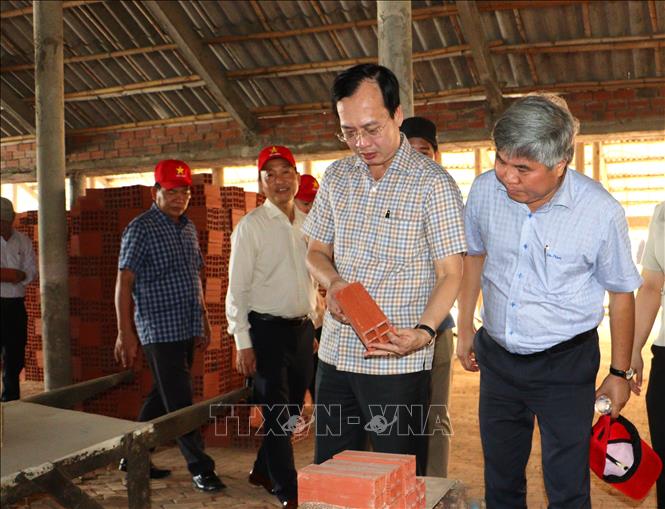 Chủ tịch Ủy ban nhân dân tỉnh Vĩnh Long Trần Trí Quang (thứ 2 từ phải sang) khảo sát thực tế tại khu vực sản xuất gạch của người dân tại xã Nhơn Phú, tỉnh Vĩnh Long.  Ảnh: Lê Thúy Hằng - TTXVN. 