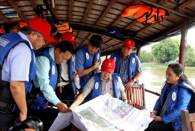 Đoàn khảo sát xem các bản vẽ quy hoạch Khu lò gạch, gốm Mang Thít tại xã Nhơn Phú , tỉnh Vĩnh Long.  Ảnh: Lê Thúy Hằng - TTXVN. 