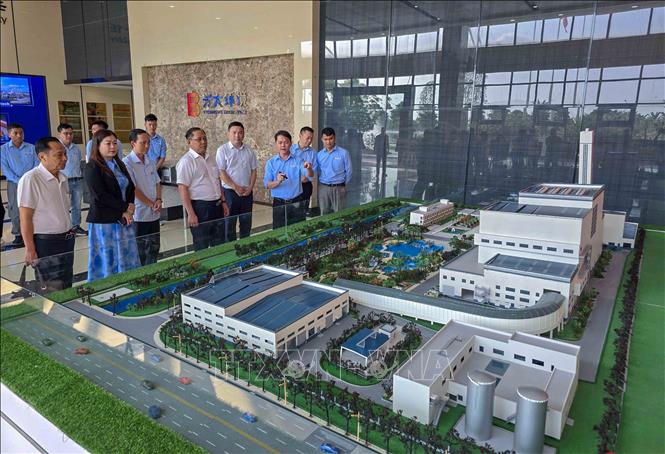Phó Chủ tịch UBND thành phố Cần Thơ Trần Chí Hùng (thứ 4 từ trái sang) xem mô hình Nhà máy xử lý chất thải rắn (rác sinh hoạt) phát điện Cần Thơ. Ảnh: Thanh Liêm - TTXVN