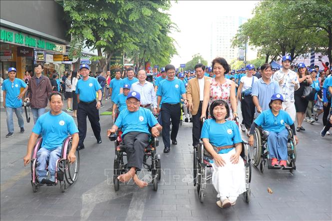 Thứ trưởng Bộ Y tế Nguyễn Thị Liên Hương và ông Nguyễn Mạnh Cường, Phó Chủ tịch Ủy ban nhân dân Thành phố Hồ Chí Minh cùng các đại biểu và người khuyết tật đi bộ đồng hành nhân Lễ kỷ niệm Ngày Người khuyết tật Việt Nam. Ảnh: Thanh Vũ-TTXVN
