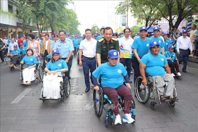 Thứ trưởng Bộ Y tế Nguyễn Thị Liên Hương và ông Nguyễn Mạnh Cường, Phó Chủ tịch Ủy ban nhân dân Thành phố Hồ Chí Minh cùng các đại biểu và người khuyết tật đi bộ đồng hành nhân Lễ kỷ niệm Ngày Người khuyết tật Việt Nam. Ảnh: Thanh Vũ-TTXVN
