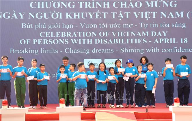 Thứ trưởng Bộ Y tế Nguyễn Thị Liên Hương và ông Nguyễn Mạnh Cường, Phó Chủ tịch Ủy ban nhân dân Thành phố Hồ Chí Minh tặng quà cho trẻ em khuyết tật và nạn nhân chất độc da cam/dioxin Việt Nam. Ảnh: Thanh Vũ-TTXVN
