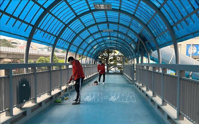 Vệ sinh các cầu vượt bộ hành, đảm bảo mỹ quan đô thị. Ảnh: Nguyễn Thắng - TTXVN