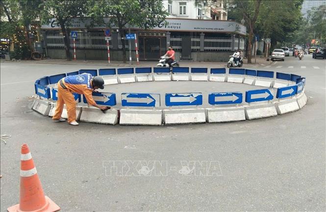 Vệ sinh các bùng binh đảo giao thông, đảm bảo mỹ quan đô thị. Ảnh: Nguyễn Thắng - TTXVN