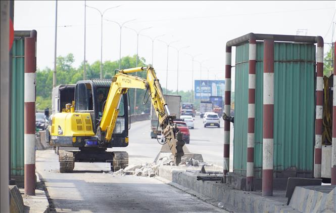Máy móc thực hiện phá bỏ các kết cấu tại trạm thu phí trên Quốc lộ 51, đoạn qua Đồng Nai. Ảnh: Công Phong - TTXVN