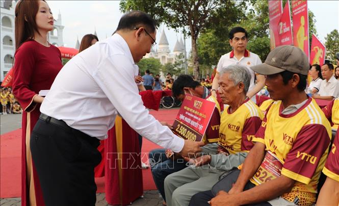 Trao bảng tượng trưng quà cho vận động viên khuyết tật. Ảnh: Hồng Thái - TTXVN