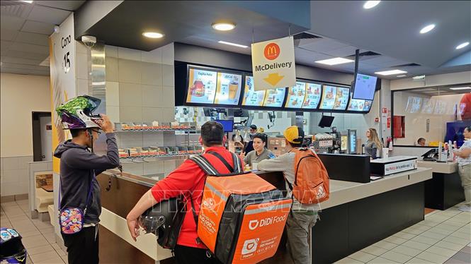Shipper đến nhận đồ ăn để ship cho khách trong một nhà hàng ăn nhanh tại thủ đô Mexico City, Mexico. Ảnh: Phi Hùng - PV TTXVN tại Mexico