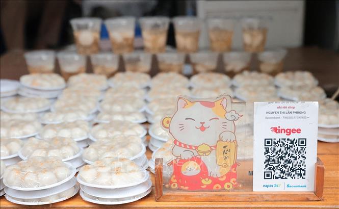 Tiểu thương ứng dụng mã QR trong thanh toán giúp việc mua bán diễn ra nhanh gọn, thuận tiện, phù hợp với xu hướng tiêu dùng hiện đại. Ảnh: Lê Đông - TTXVN