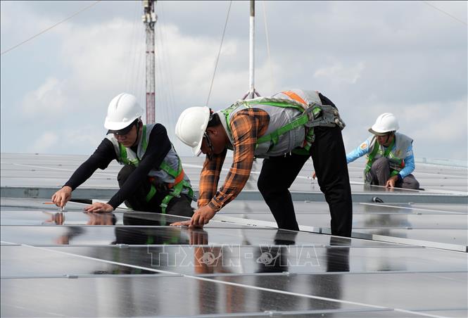 Lắp đặt tấm pin năng lượng điện mặt trời, giảm chi phí trong mùa nắng nóng. Ảnh: Trung Hiếu. TTXVN