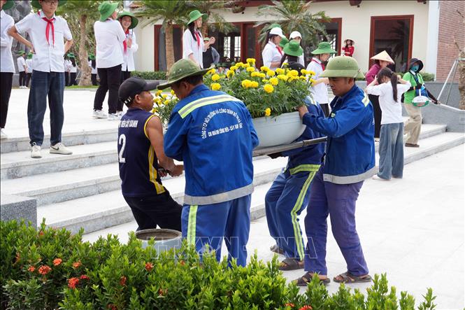 Công nhân vận chuyển cây cảnh để trang trí tại Khu lưu niệm Tổng Bí thư Hà Huy Tập. Ảnh: Hữu Quyết - TTXVN 