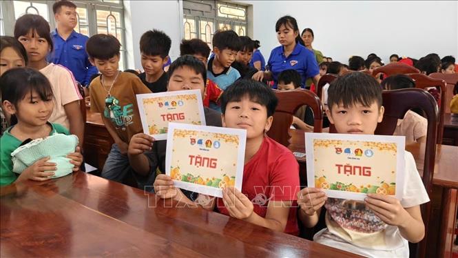 Học sinh phấn khởi nhận học bổng tại chương trình. Ảnh: K GỬIH-TTXVN