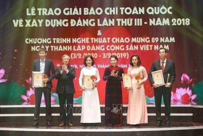 Chủ tịch Quốc hội Nguyễn Thị Kim Ngân và đồng chí Trần Quốc Vượng, Ủy viên Bộ Chính trị, Thường trực Ban Bí thư trao giải A cho tác giả và nhóm tác giả đoạt giải tạ Lễ trao Giải báo chí toàn quốc về xây dựng Đảng (Giải Búa liềm vàng) lần thứ III - năm 2018. Ảnh: Doãn Tấn - TTXVN