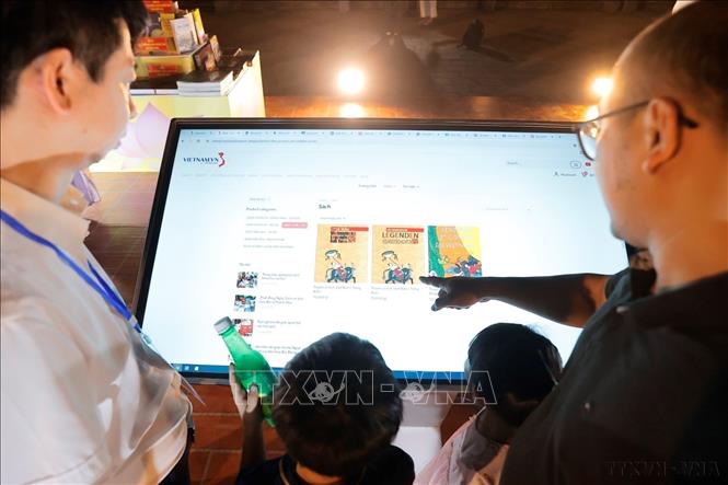 Khách tham quan trải nghiệm ứng dụng sách điện tử tại Lễ khai mạc Ngày Sách và Văn hóa đọc Việt Nam lần thứ ba năm 2024 do Ban Tuyên giáo Trung ương phối hợp với Bộ Thông tin và Truyền thông, UBND thành phố Hà Nội, Bộ Văn hóa, Thể thao và Du lịch, Hội Xuất bản Việt Nam tổ chức, tối 17/4/2024, tại Văn Miếu - Quốc Tử Giám (Hà Nội). Ảnh: Minh Quyết - TTXVN