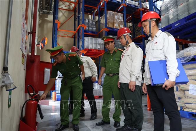 Cán bộ Đội CC và CNCH khu vực 21 kiểm tra bình chữa cháy mini trong nhà xưởng doanh nghiệp. Ảnh: Hồng Đạt - TTXVN