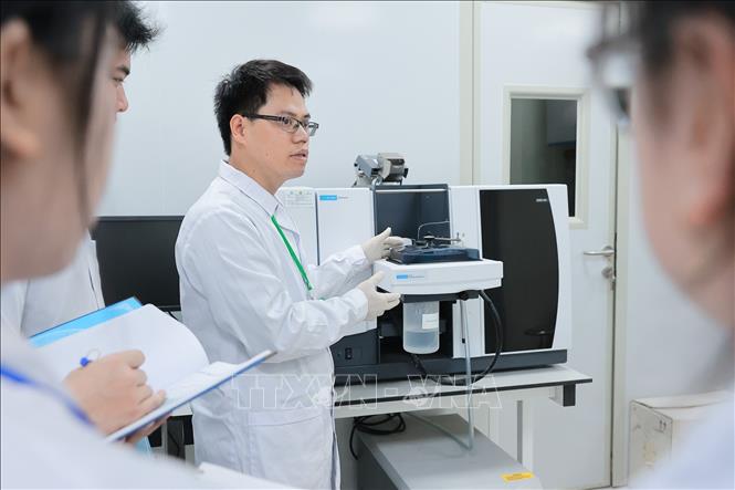 Sinh viên Khoa Tài nguyên và môi trường được giảng viên trực tiếp hướng dẫn sử dụng Máy quang phổ hấp thụ nguyên tử dùng để kiểm tra chất lượng nước, thực phẩm, dược phẩm, đất, môi trường. Ảnh: Lê Đông - TTXVN