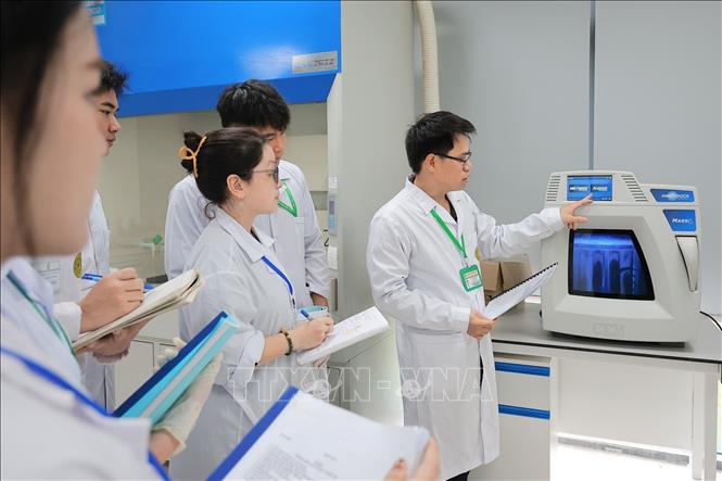 Giảng viên hướng dẫn sinh viên Khoa Tài nguyên và môi trường sử dụng máy phá mẫu vi sóng (Mars6) để phá hủy, phân hủy các mẫu hữu cơ và vô cơ (thực phẩm, đất, nước, dược phẩm) bằng axit đậm đặc dưới nhiệt độ và áp suất cao. Ảnh: Lê Đông - TTXVN