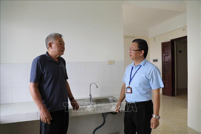 Ông Vũ Văn Hoạt (trái), Chủ tịch UBND phường Vĩnh Tuy, Hà Nội trao đổi với người dân thuộc diện tái định cư. Ảnh: Quốc Lũy - TTXVN