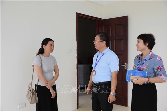 Chị Lê Thị Thương (đầu tiên, trái sang) trò chuyện với lãnh đạo phường Vĩnh Tuy đến thăm hỏi, động viên. Ảnh: Quốc Lũy - TTXVN