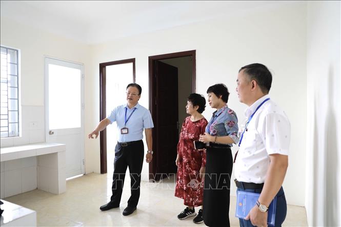 Bà Đinh Thị Biên (thứ 2, trái qua) phấn khởi tại nơi tái định cư. Ảnh: Quốc Lũy - TTXVN