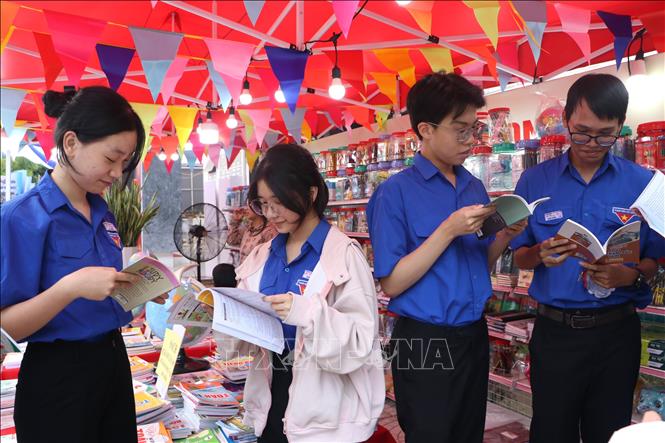 Học sinh đọc sách tại các gian trưng bày. Ảnh: Đinh Hương - TTXVN