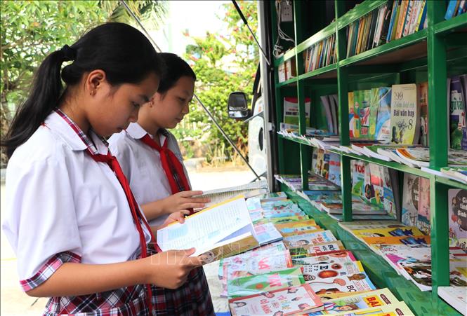 Học sinh đọc sách tại các gian trưng bày. Ảnh: Đinh Hương - TTXVN