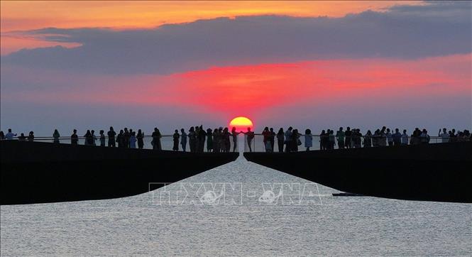 Du khách ngắm hoàng hôn trên Cầu Hôn, đặc khu Phú Quốc (An Giang). Ảnh: TTXVN phát