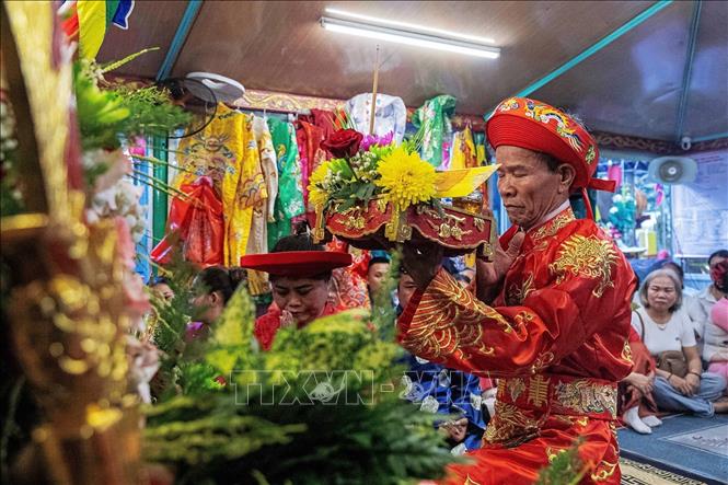 Thực hành nghi lễ hầu đồng và cầu nguyện bên trong các bằng, án. Ảnh: Vân Chi/TTXVN phát