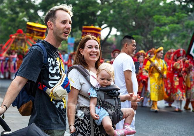 Du khách nước ngoài thích thú khi được chiêm ngưỡng đoàn rước Mẫu đầy màu sắc trên phố. Ảnh: Vân Chi/TTXVN phát
