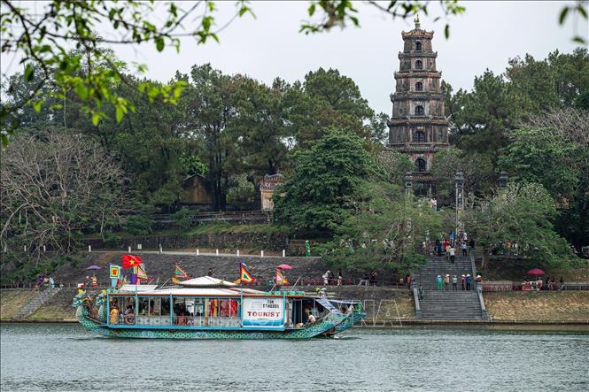 Đoàn rước bằng thuyền cung nghinh Thánh Mẫu đi qua chùa Thiên Mụ. Ảnh: Vân Chi/TTXVN phát
