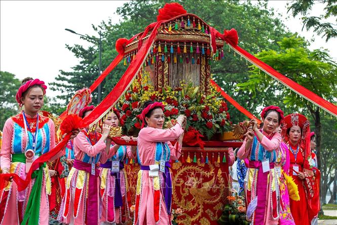 Kiệu rước Thánh Mẫu và Hội đồng Tứ phủ được hộ tống bởi nhiều người, tiến về phía Công viên Thương Bạc. Ảnh: Vân Chi/TTXVN phát
