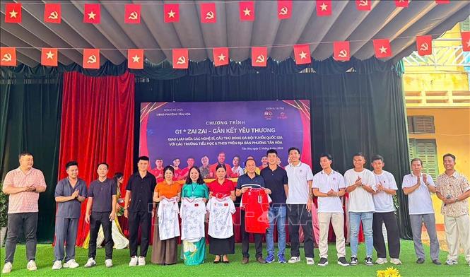 Các cầu thủ đội tuyển quốc gia Việt Nam trao tặng áo đấu cho học sinh nghèo có hoàn cảnh khó khăn. Ảnh: Thanh Hải - TTXVN  