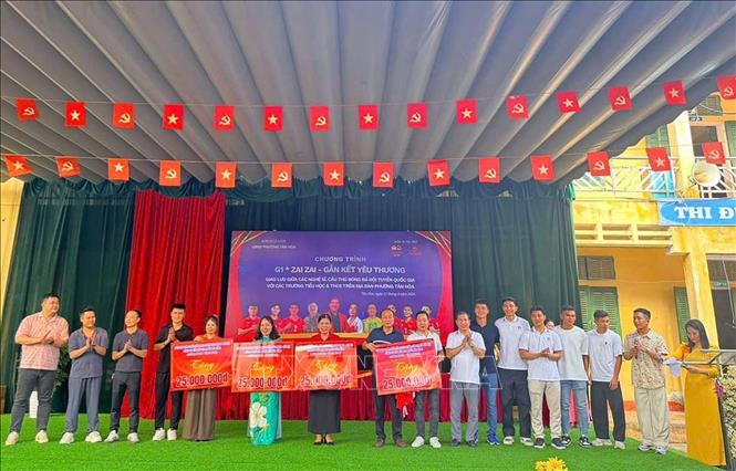Ban tổ chức trao tặng học bổng với tổng trị giá 100 triệu đồng cho 4 trường tiểu học và trung học cơ sở trên địa bàn. Ảnh: Thanh Hải - TTXVN 