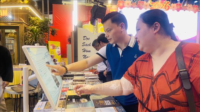 Đại diện thương hiệu Book Hunter hướng dẫn độc giả trải nghiệm nền tảng Book Hunter Plus. Ảnh: Tuyết Mai - TTXVN 