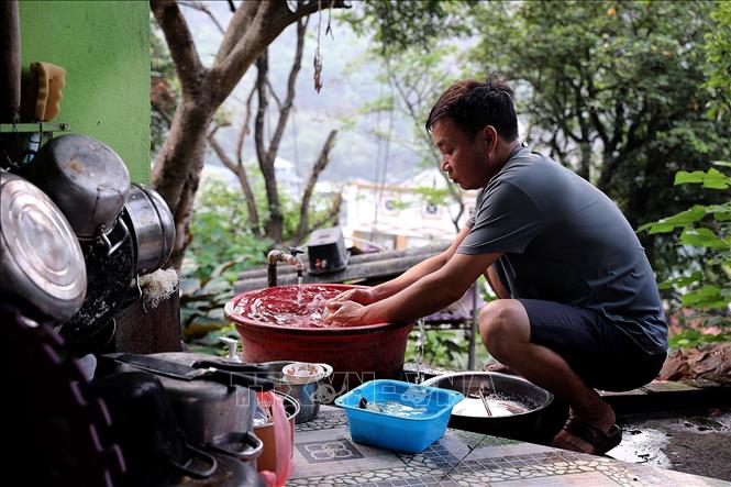Người dân xóm Tiểu Khu chung nhau sử dụng một nguồn nước nhà bà Đinh Thị Bình để sinh hoạt hàng ngày. Ảnh: Thanh Hải - TTXVN   