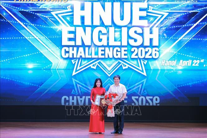 PGS.TS Kiều Văn Hoan, Phó Hiệu trưởng Trường Đại học Sư phạm Hà Nội trao hoa và giấy cảm ơn nhà tài trợ đồng hành cùng nhà trường. Ảnh: Lê Đông - TTXVN