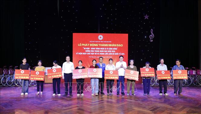 Ban tổ chức trao kinh phí hỗ trợ xây dựng nhà nhân đạo cho các gia đình có hoàn cảnh khó khăn. Ảnh: Thu Hằng - TTXVN