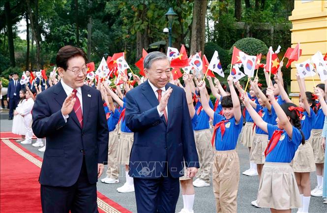 Tổng Bí thư, Chủ tịch nước Tô Lâm và Tổng thống Hàn Quốc Lee Jae Myung với thiếu nhi Thủ đô Hà Nội tại lễ đón. Ảnh: Thống Nhất – TTXVN

