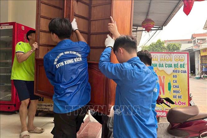 Đoàn Thanh niên xã Như Quỳnh cùng sinh viên Đại học Kinh tế - Quản trị kinh doanh và cán bộ, chiến sỹ Tiểu đoàn Cảnh sát cơ động số 3 hỗ trợ người dân xã Như Quỳnh vận chuyển đồ đạc, bàn giao mặt bằng. Ảnh: Thu Hoài - TTXVN 
