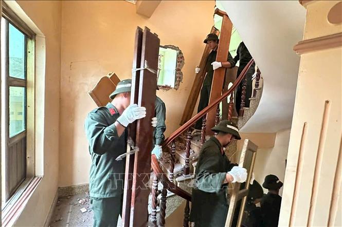 Cán bộ, chiến sỹ Tiểu đoàn Cảnh sát cơ động số 3 hỗ trợ người dân xã Như Quỳnh vận chuyển đồ đạc, bàn giao mặt bằng. Ảnh: Thu Hoài - TTXVN 