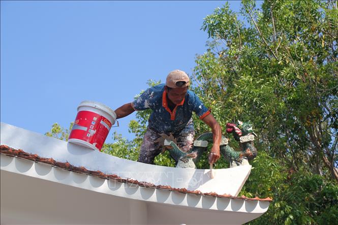 Công nhân quét sơn phần mái trong khuôn viên khu Di tích quốc gia Địa điểm Trận Giồng Bốm. Ảnh: Chanh Đa - TTXVN
