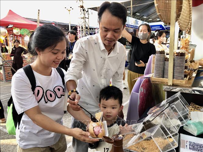 Nhiều gia đình đưa con nhỏ đến trải nghiệm bánh mì kem đặc sản Sài Gòn xưa. Ảnh: Mỹ Phương - TTXVN